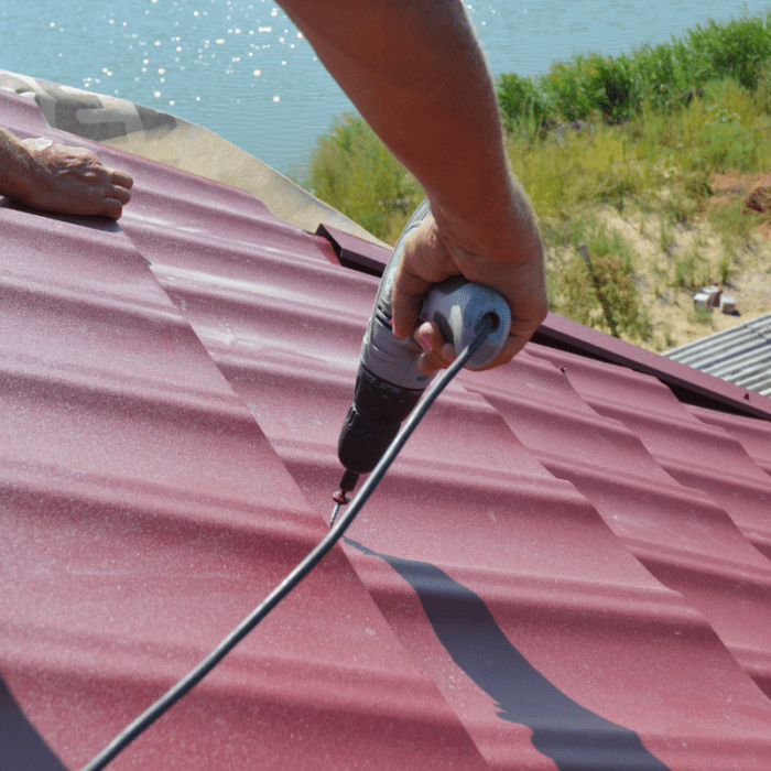 Roofer working on metal roof